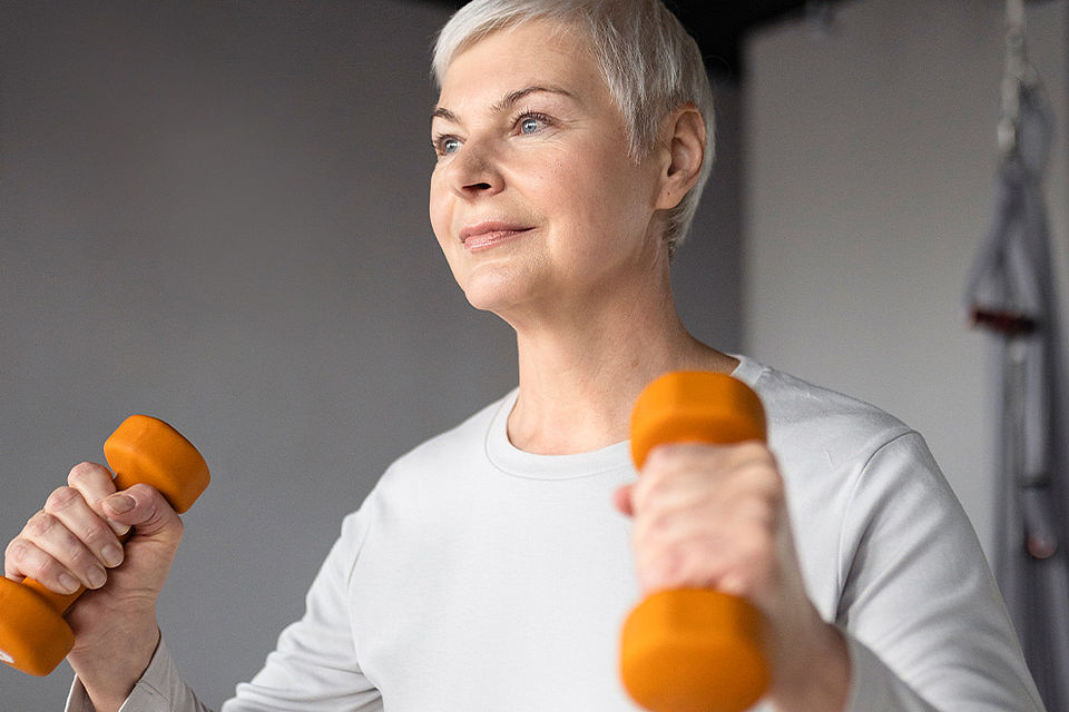 Functional Training 60+ im DRK-Treffpunkt Barmbek Ältere Frau trainiert beim Functional Training mit zwei Hanteln.