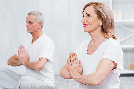 Frau und Mann führen gemeinsam eine Qi-Gong-Übung aus