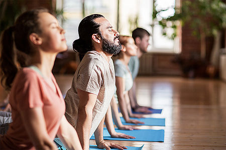 Teilnehmende bei einer Hatha-Yoga-Übung auf Yogamatten