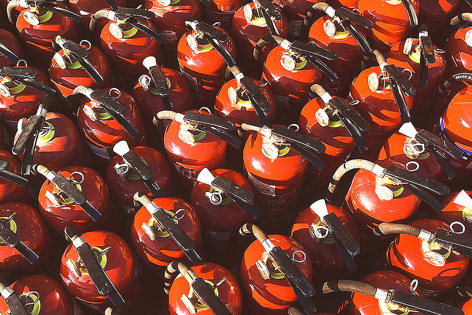 Feuerlöscher für die Brandschutz-Fortbildung Mehrere rote Feuerlöscher, die bei einer Brandschutz-Fortbildung für praktische Löschübungen eingesetzt werden.